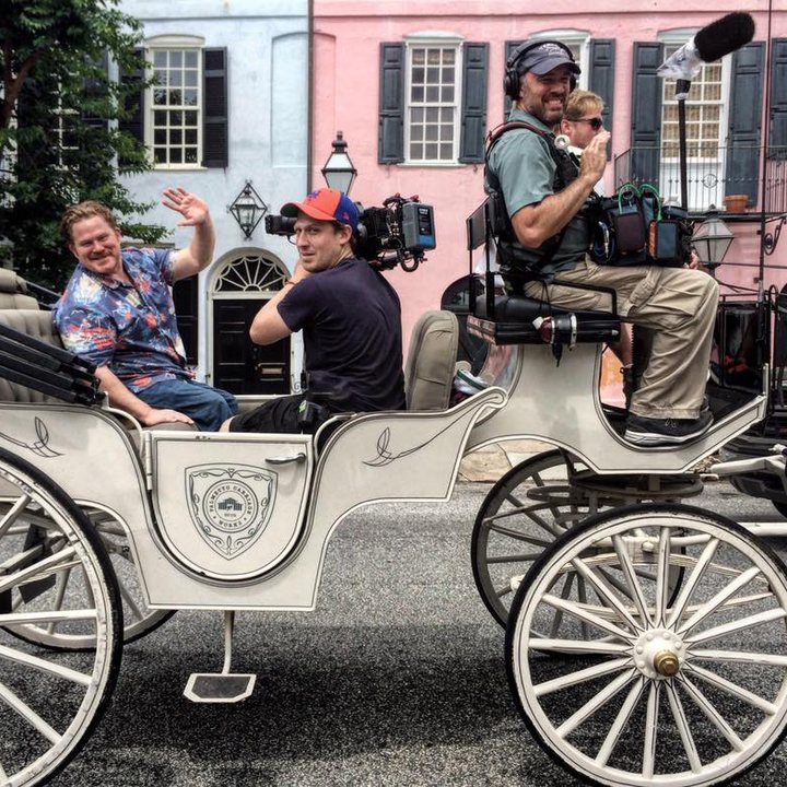 Brandon filming from a horse-drawn carriage on a documentary shoot